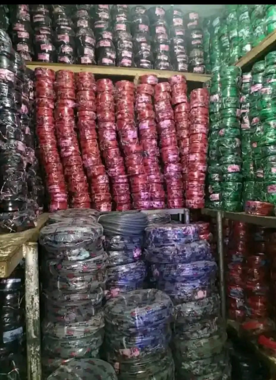 Shelves stacked with coils of red, green, black and blue electrical cable