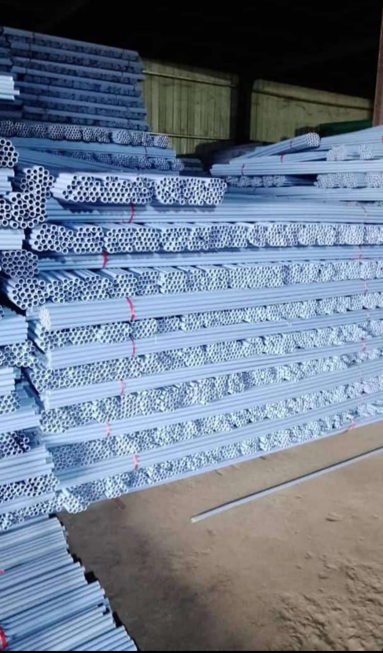 Bundles of white PVC conduit pipes stacked in the warehouse